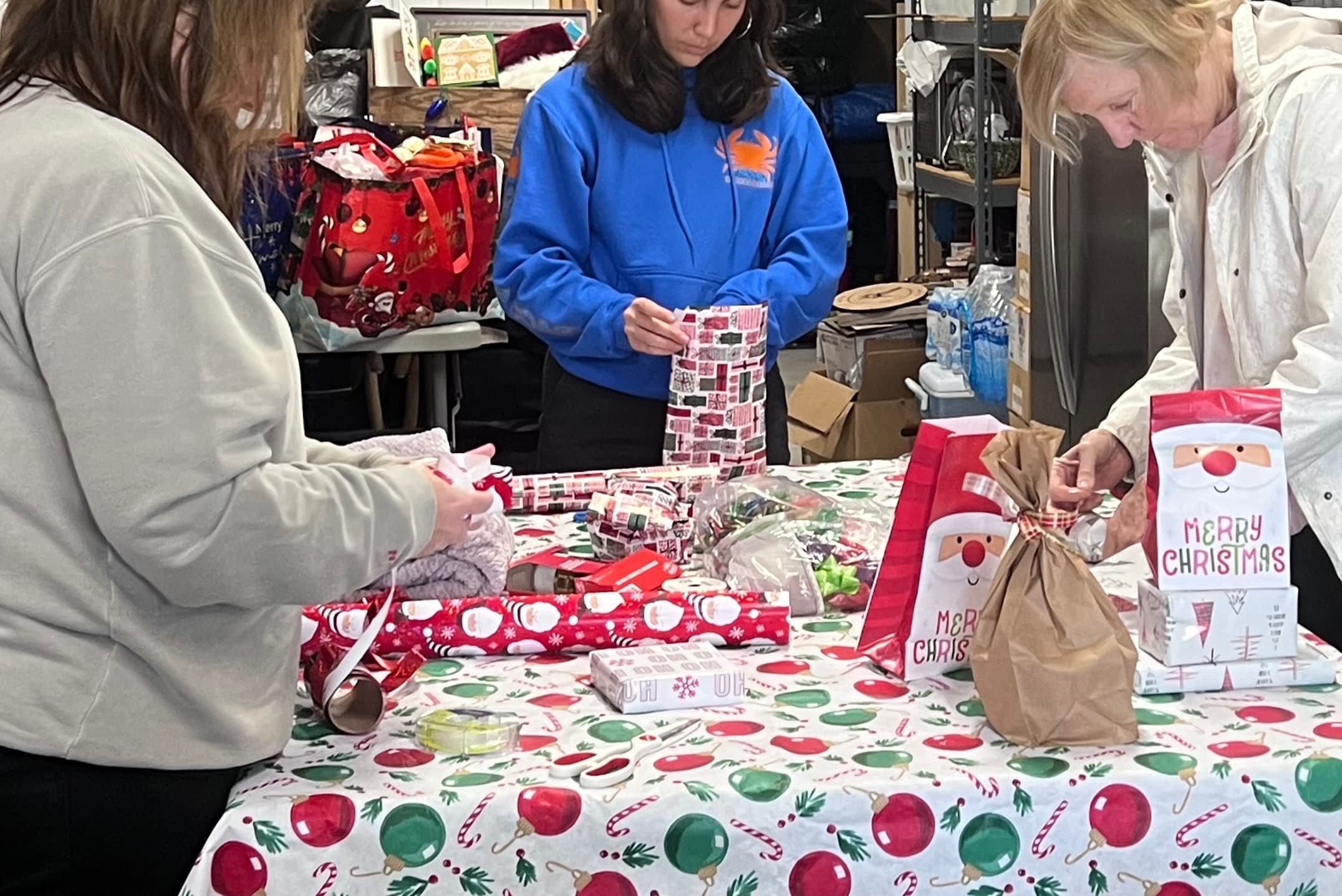 Part of the team wrapping Christmas gifts so each item is a surprise waiting to be unwrapped.